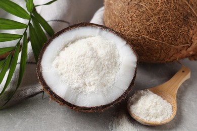 Photo of Organic coconut flour, fresh fruit and leaf on light grey table, closeup