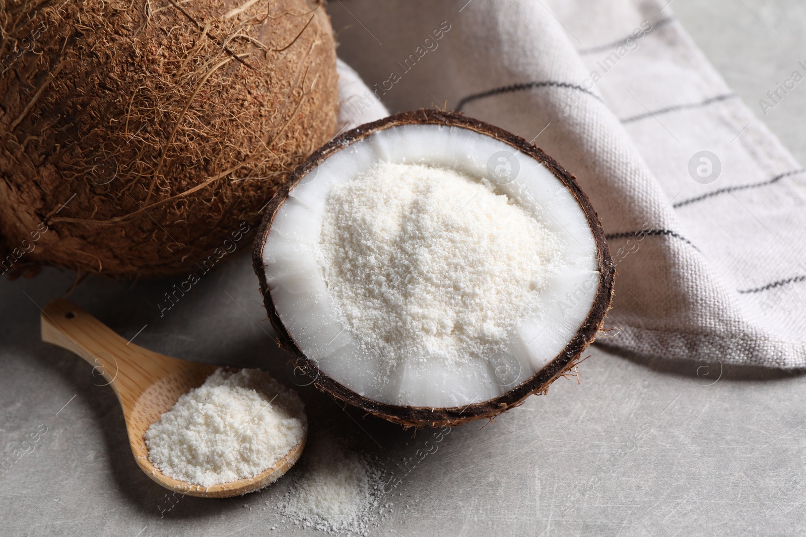 Photo of Organic coconut flour and fresh fruit on light grey table, closeup