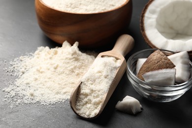 Photo of Coconut flour and fruit pieces on dark grey table, closeup