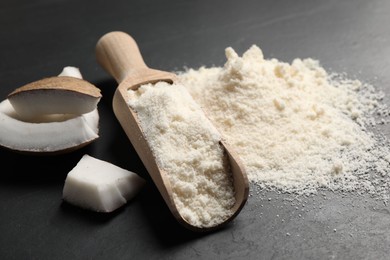 Photo of Coconut flour and fruit pieces on dark grey table, closeup