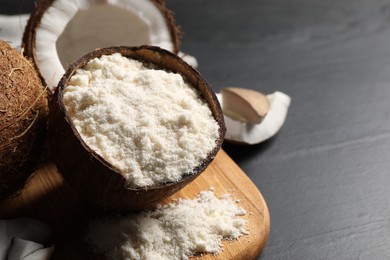 Photo of Organic coconut flour and fresh fruits on black table, closeup. Space for text