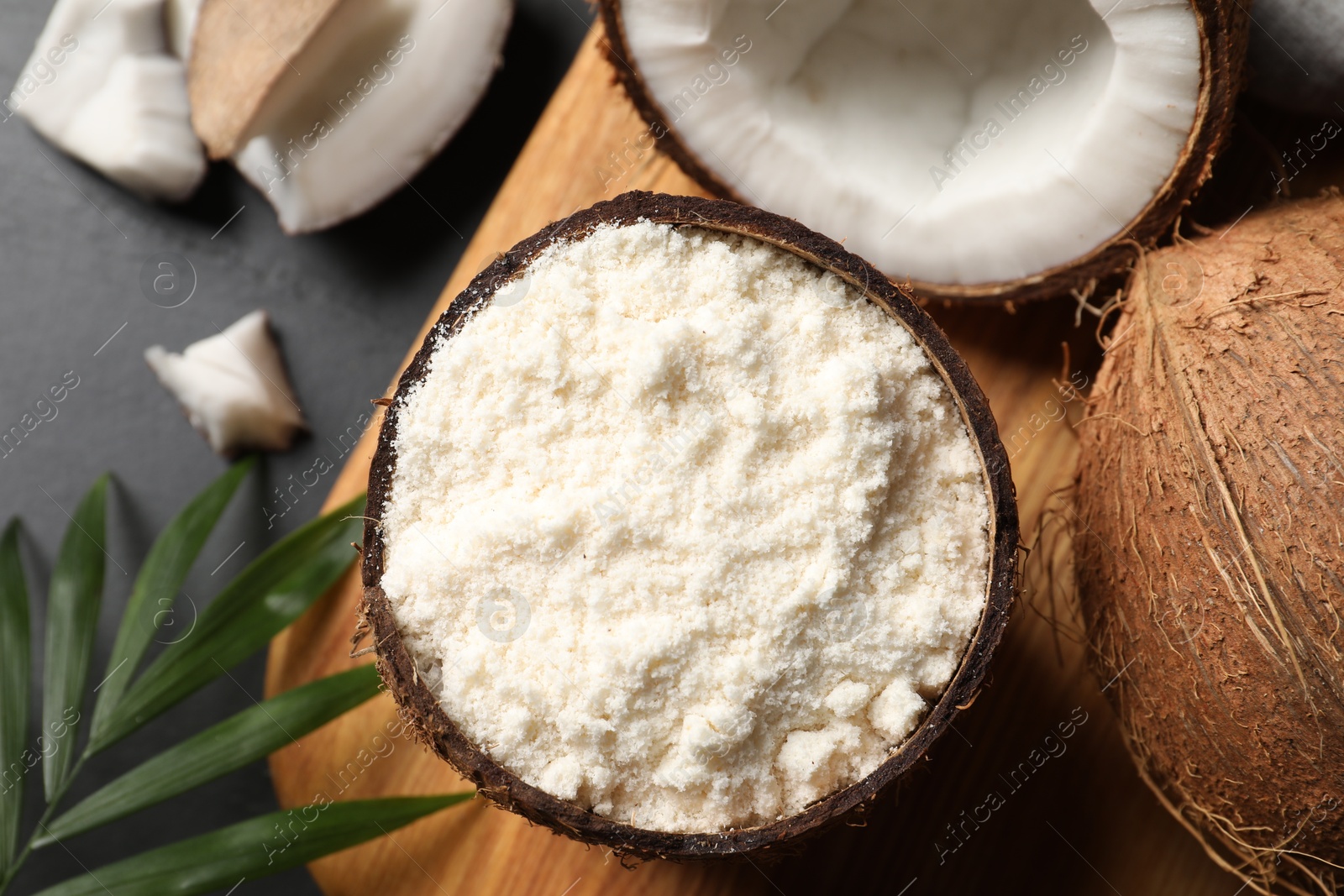 Photo of Organic coconut flour and fresh fruits on black table, flat lay