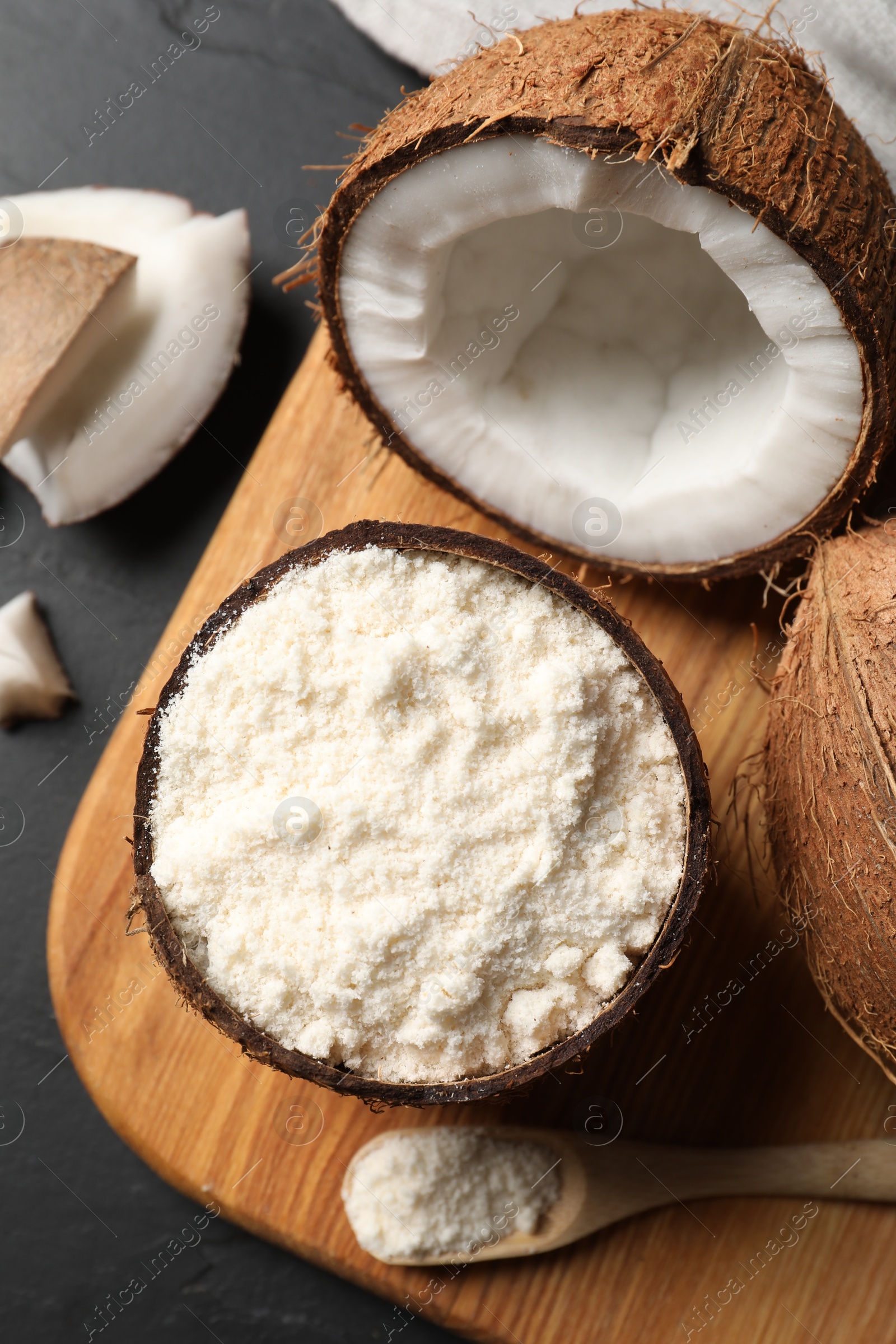 Photo of Organic coconut flour and fresh fruits on black table, flat lay