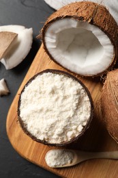 Photo of Organic coconut flour and fresh fruits on black table, flat lay