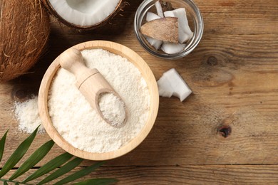 Photo of Coconut flour in bowl, scoop and fresh fruits on wooden table, flat lay. Space for text