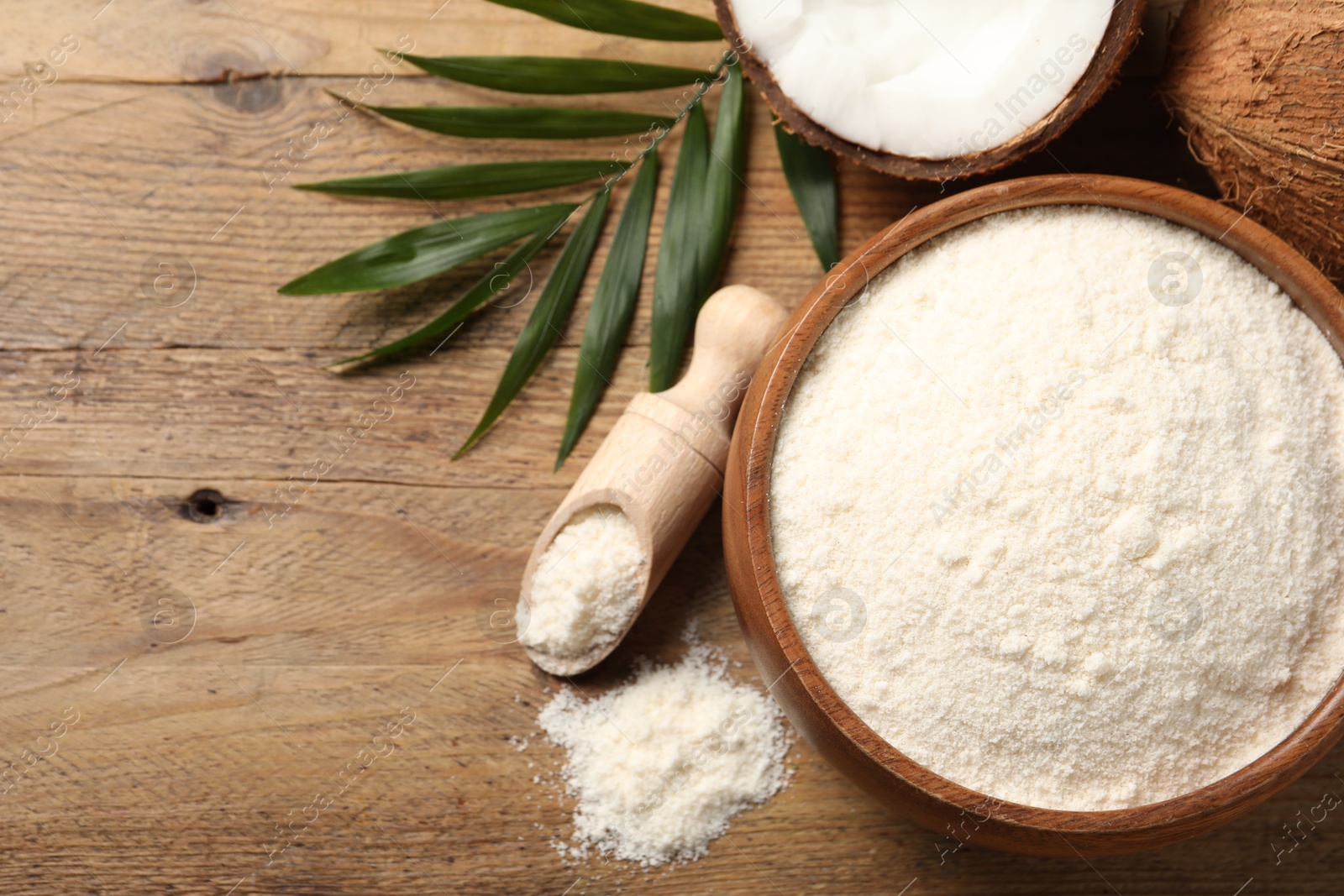 Photo of Coconut flour, fresh fruits and leaf on wooden table, flat lay. Space for text