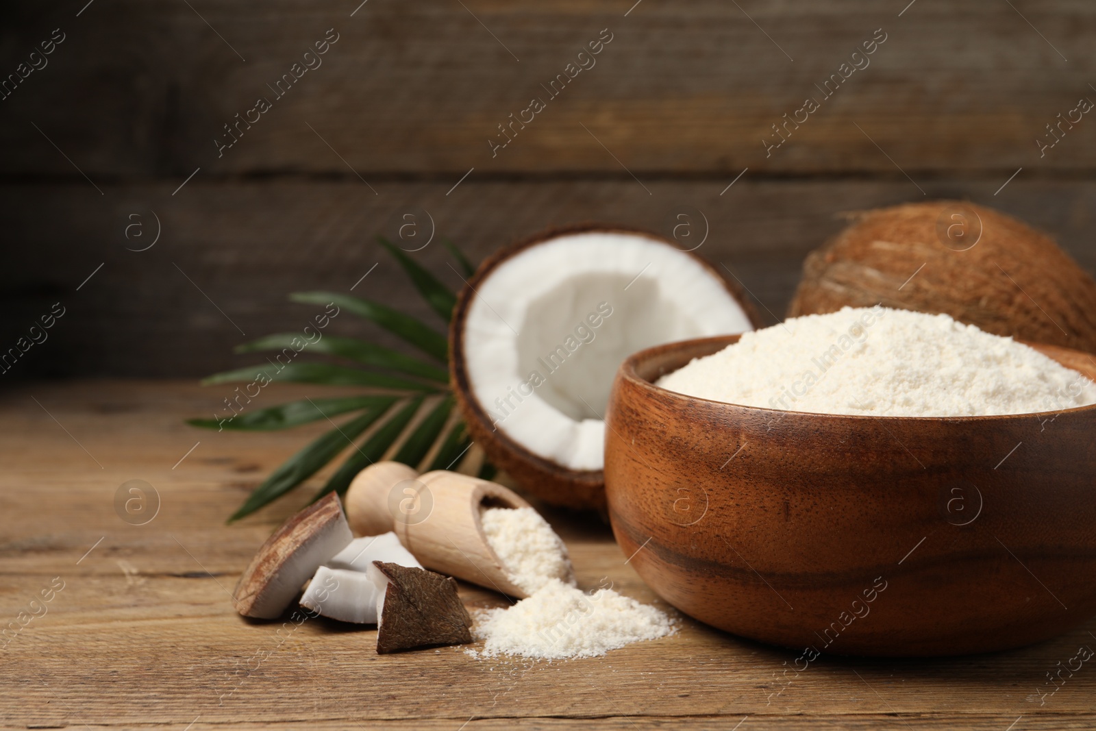 Photo of Coconut flour and fresh fruits on wooden table, closeup. Space for text