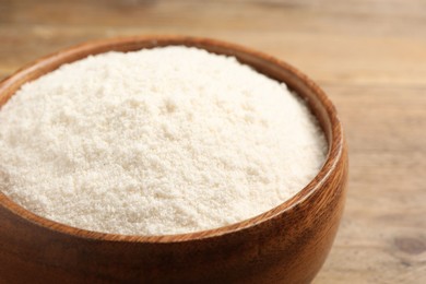 Photo of Coconut flour in bowl on table, closeup