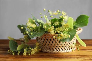 Fresh linden leaves and flowers on wooden table