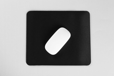 Wireless mouse and mousepad on white background, top view