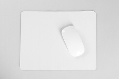 Wireless mouse and mousepad on white background, top view