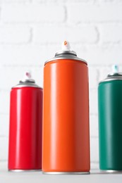 Photo of Cans of spray paint on grey table, low angle view