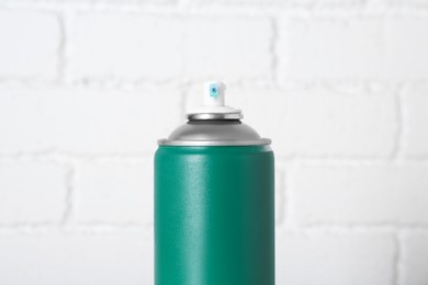 Photo of Can of spray paint near white brick wall, closeup