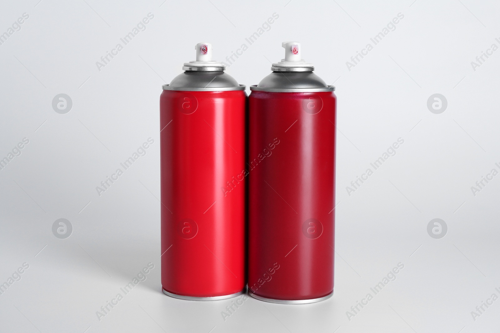 Photo of Cans of spray paint on white background