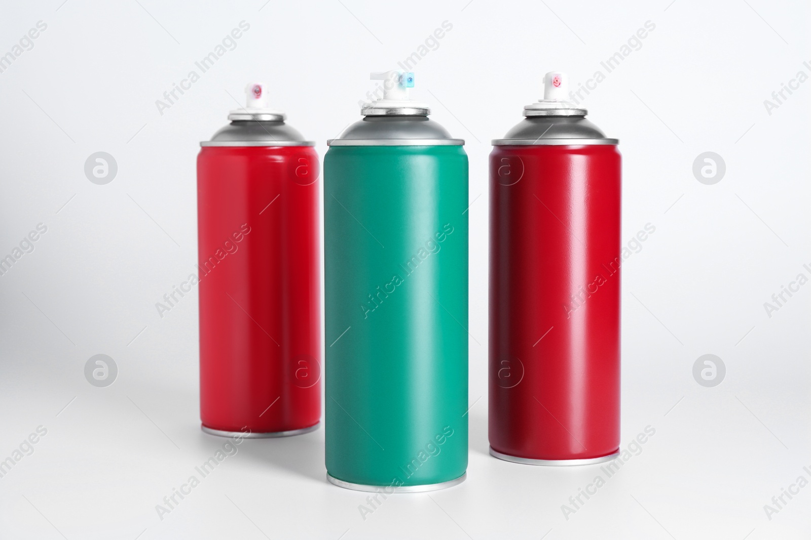 Photo of Cans of spray paint on white background