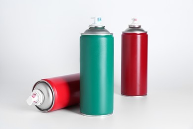 Cans of spray paint on white background