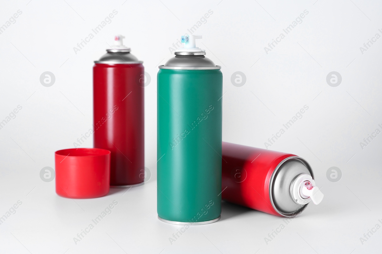 Photo of Cans of spray paint on white background