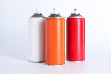 Cans of spray paint on white background