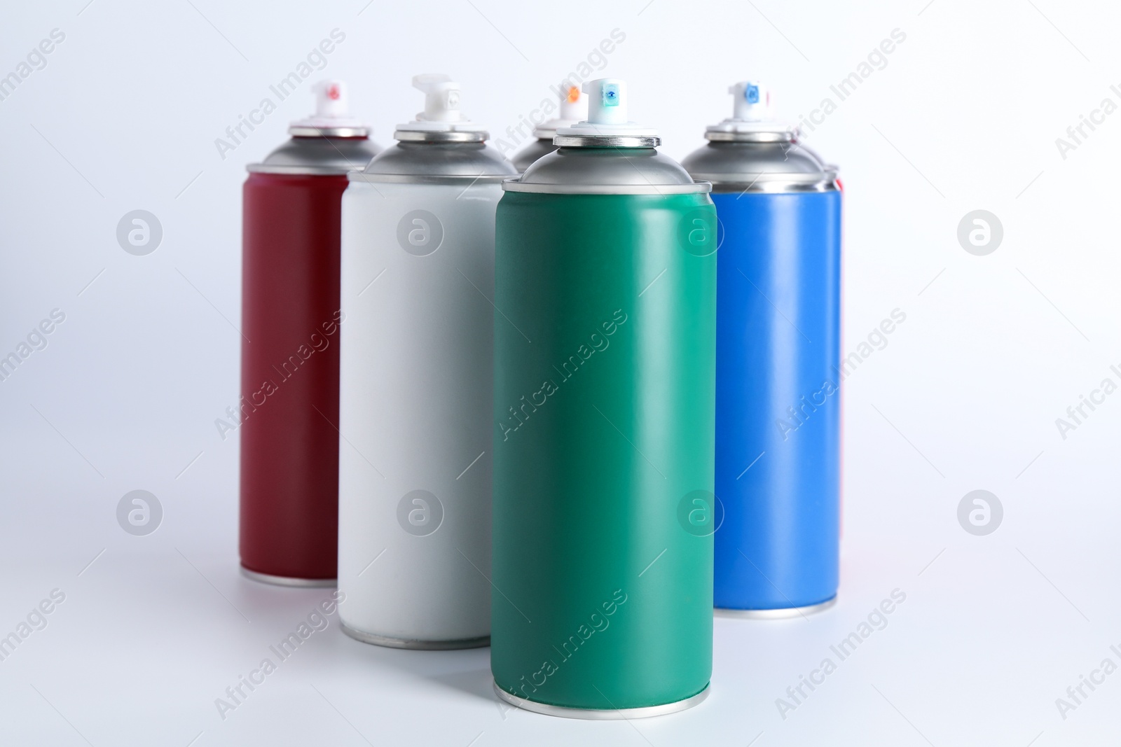 Photo of Cans of spray paint on white background