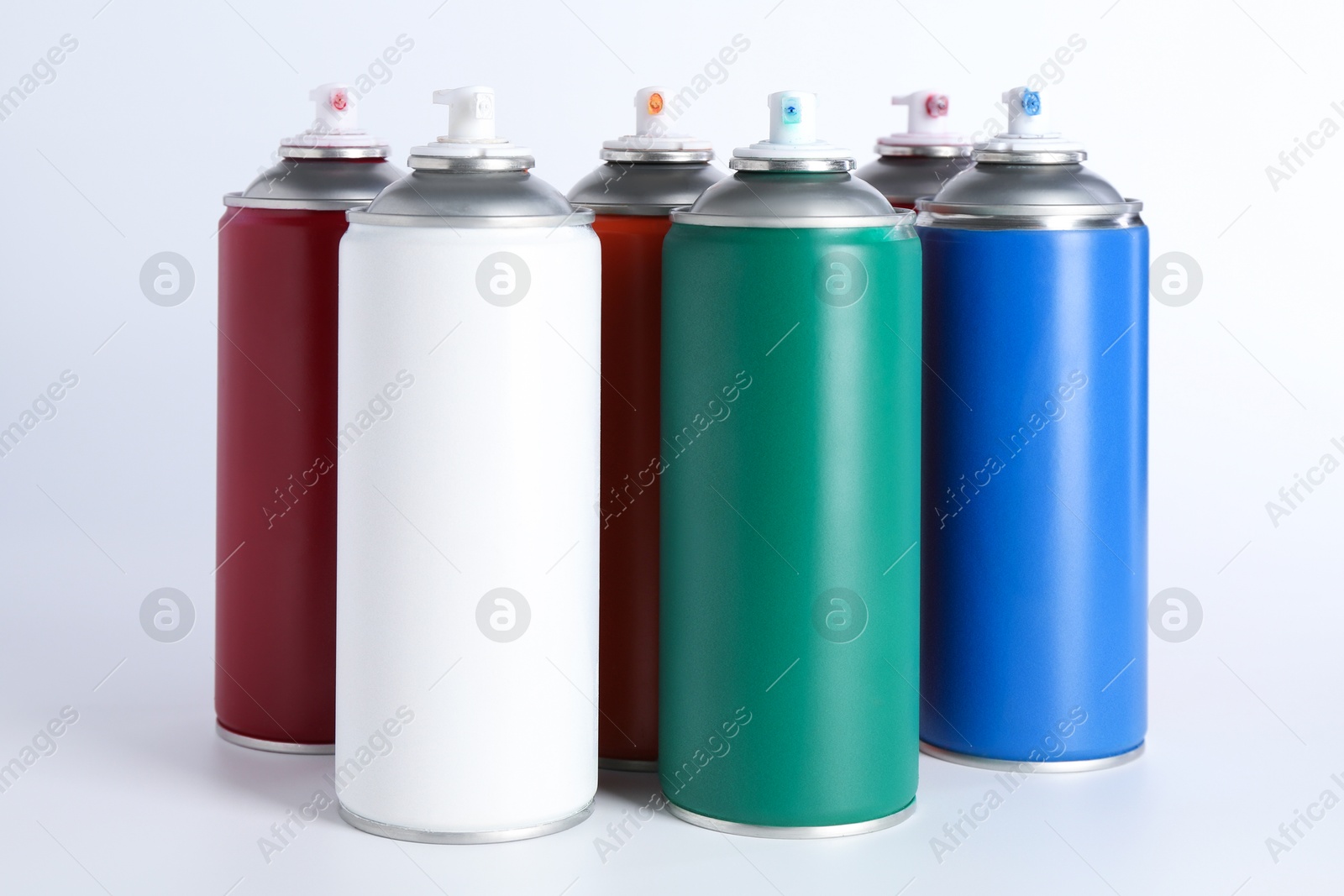 Photo of Cans of spray paint on white background