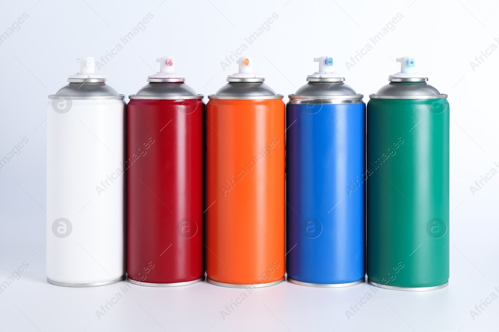 Photo of Cans of spray paint on white background