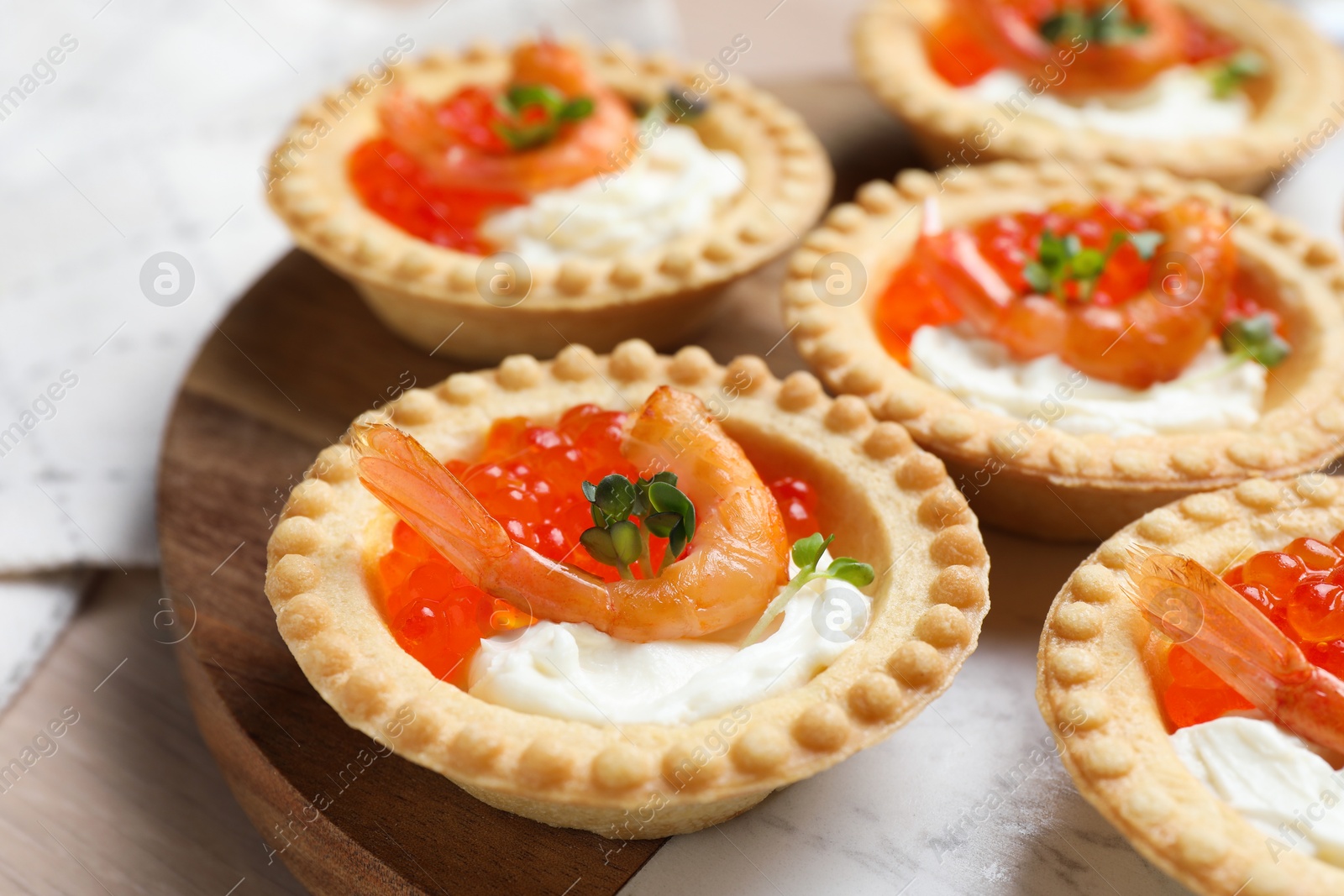 Photo of Delicious canapes with shrimps, red caviar and cream cheese on light table, closeup