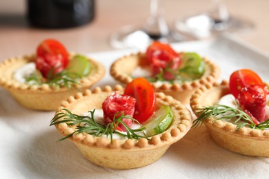 Photo of Delicious canapes with dry smoked sausages, cream cheese and vegetables on table, closeup