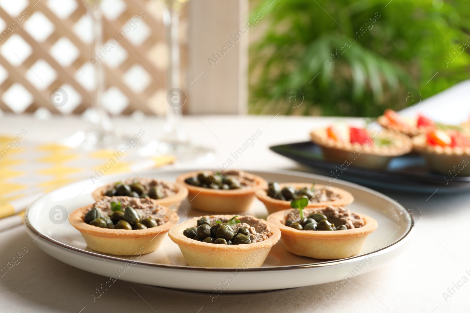 Photo of Delicious canapes with pate and capers on white table