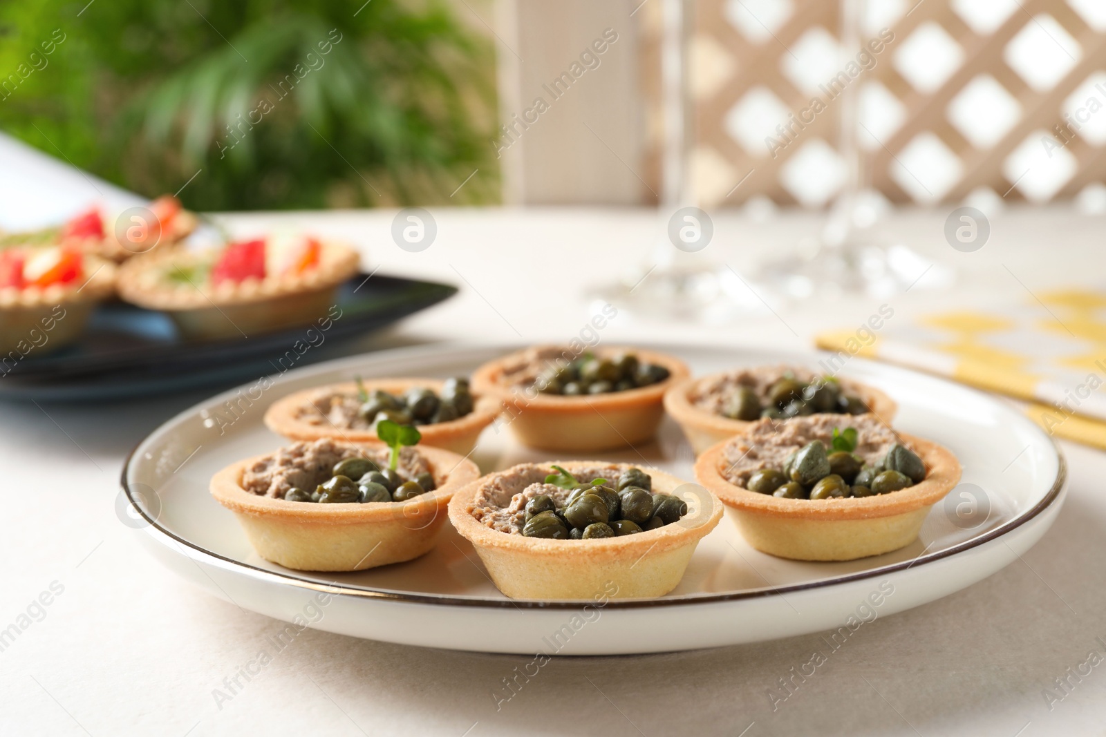 Photo of Delicious canapes with pate and capers on white table