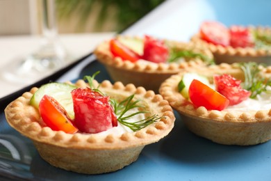 Photo of Delicious canapes with dry smoked sausages, cream cheese and vegetables on table, closeup