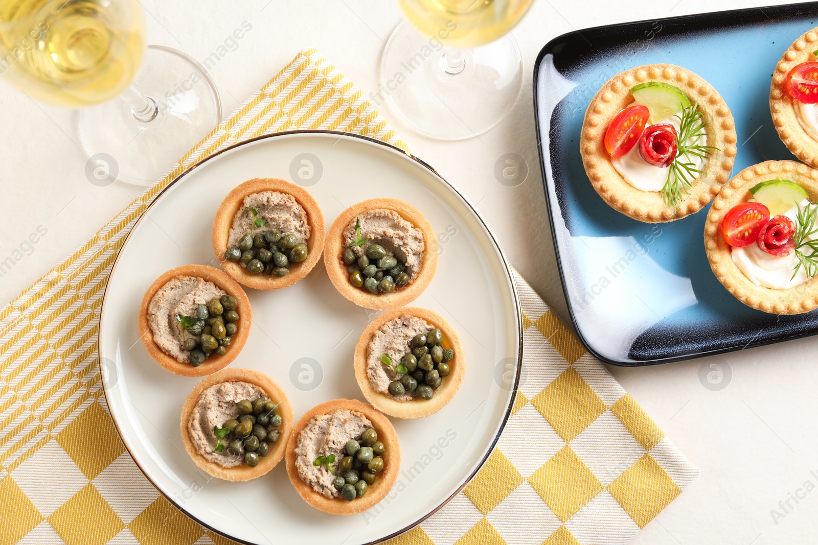 Photo of Delicious canapes served on light table, flat lay