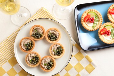 Photo of Delicious canapes served on light table, flat lay