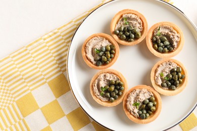 Photo of Delicious canapes with pate and capers on light table, top view