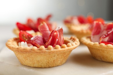 Photo of Delicious canapes with jamon, cream cheese and cherry tomatoes on table, closeup