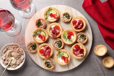 Delicious canapes served on grey textured table, flat lay