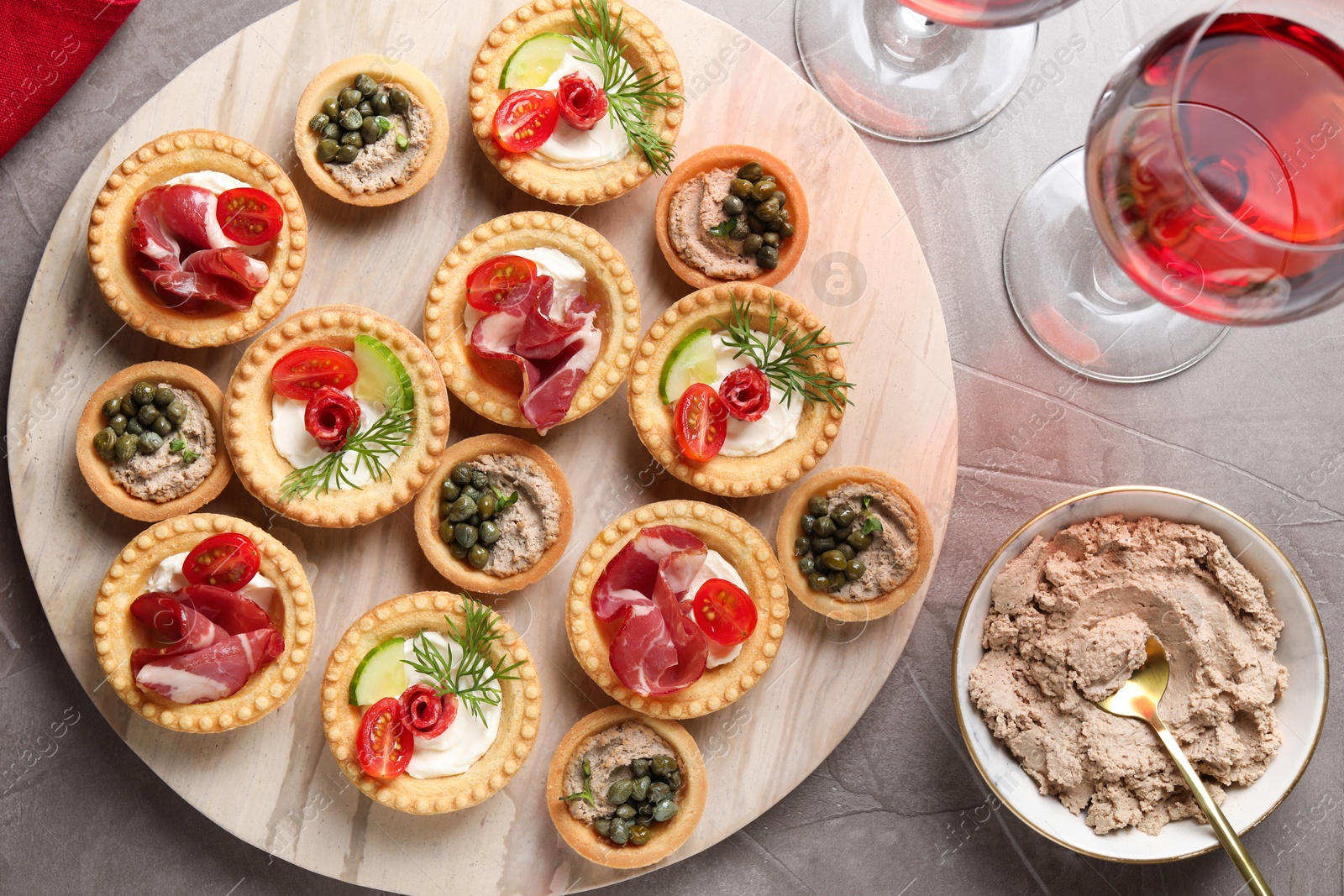 Photo of Delicious canapes served on grey textured table, flat lay