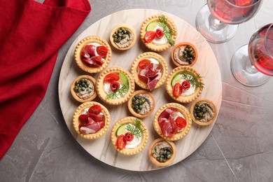 Delicious canapes served on grey textured table, flat lay