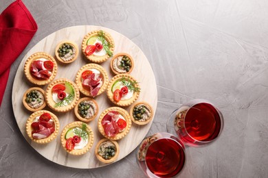 Photo of Delicious canapes served on grey textured table, flat lay