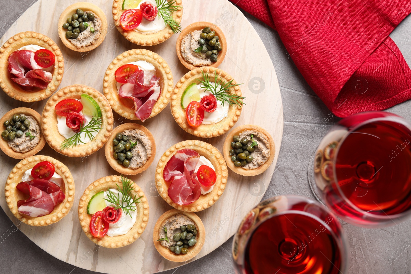 Photo of Delicious canapes served on grey textured table, flat lay