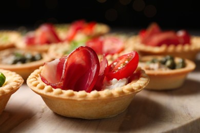 Photo of Delicious canapes with jamon, cream cheese and tomato on table, closeup