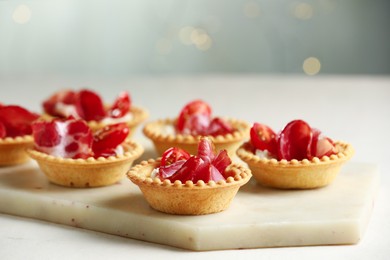 Delicious canapes with jamon on white table, closeup