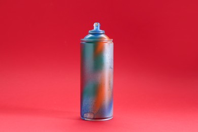 Photo of One can of bright spray paint on red background