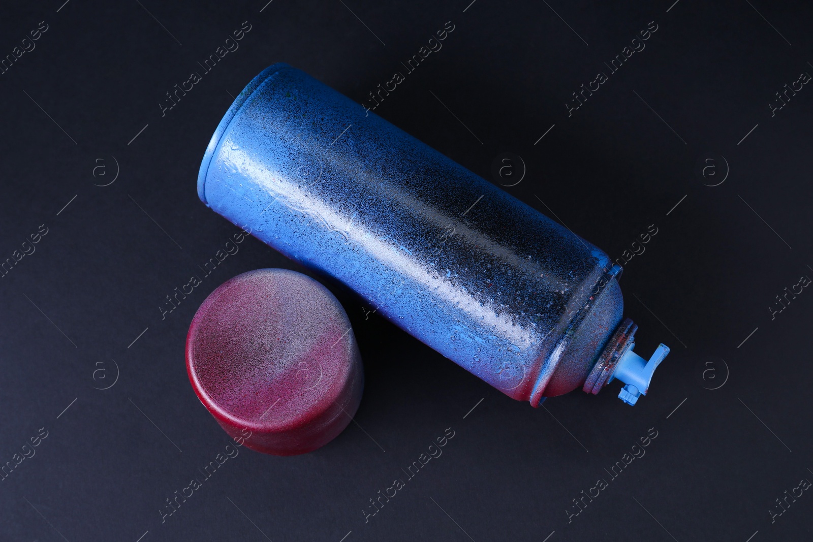 Photo of One spray paint can with cap on dark background, top view