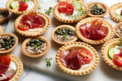 Photo of Different delicious canapes on white table, closeup