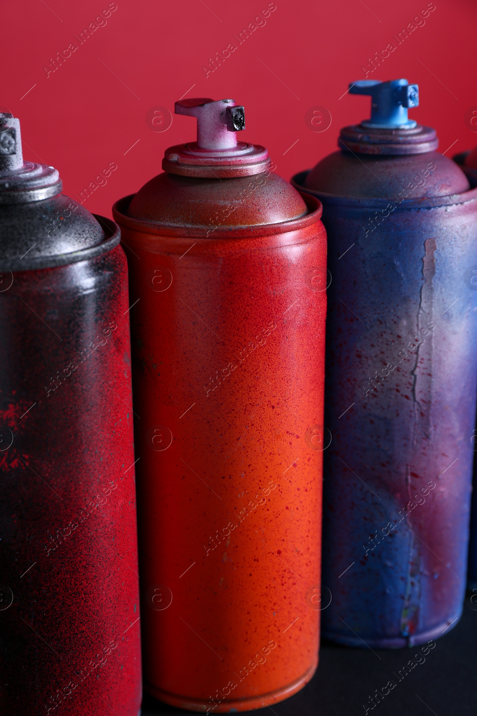 Photo of Many spray paint cans on color background, closeup