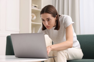 Woman with poor posture using laptop at home