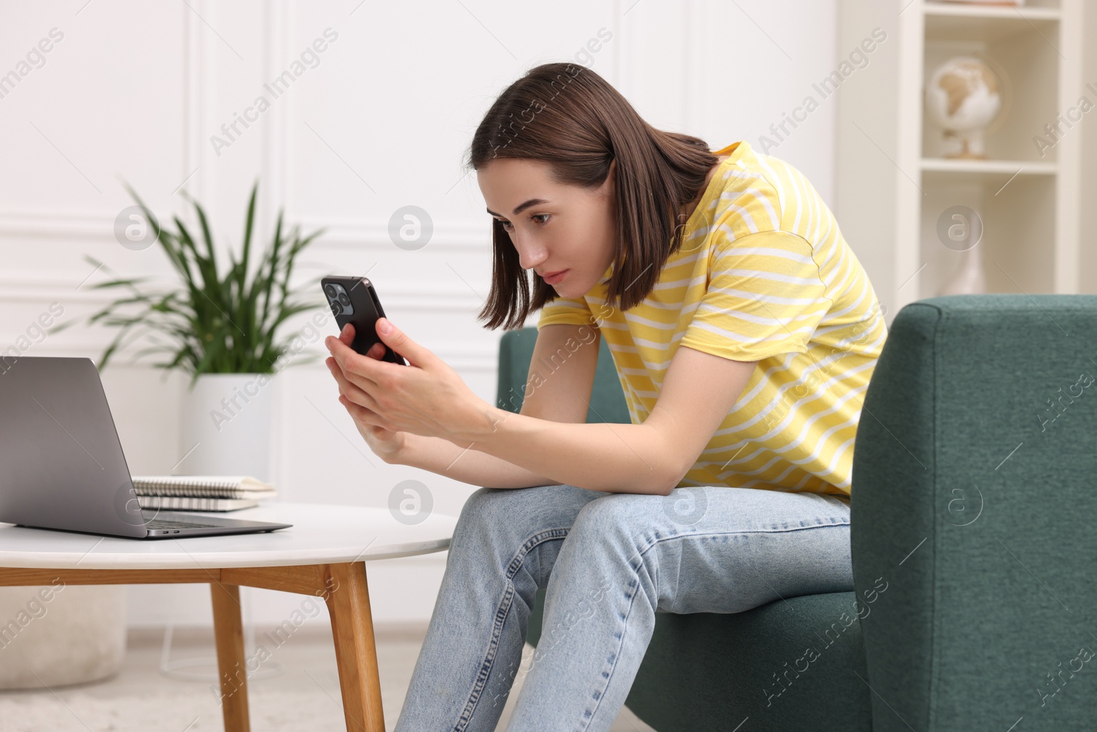 Photo of Woman with poor posture using smartphone at home