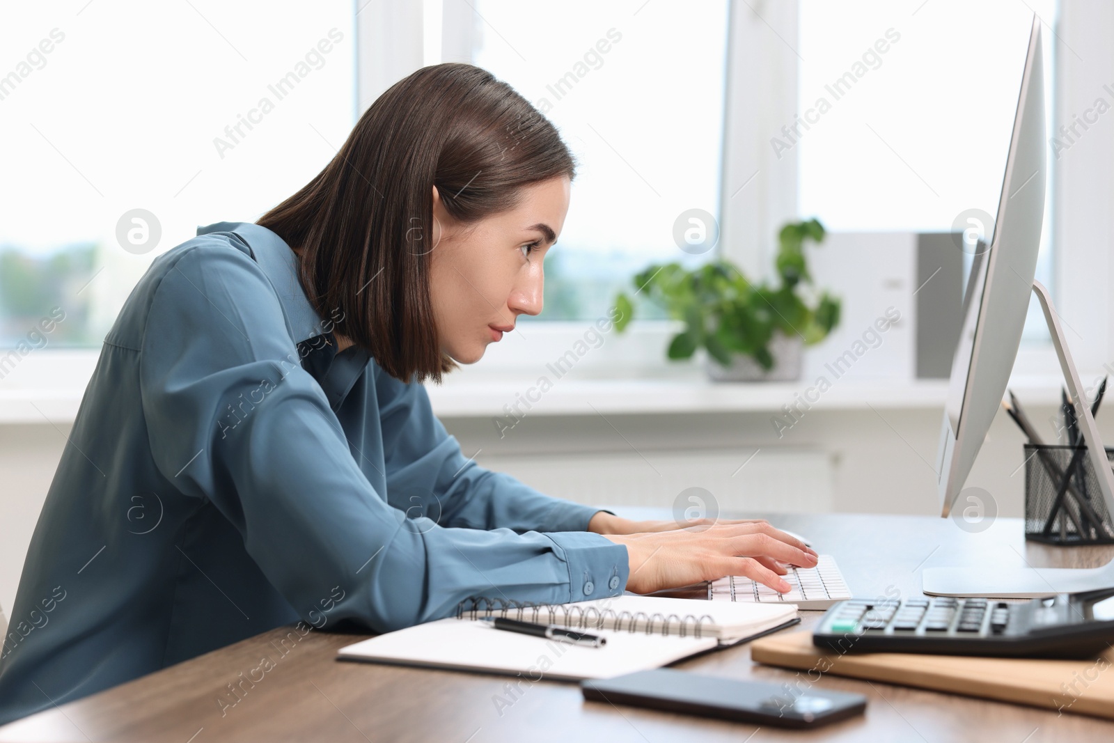 Photo of Woman with poor posture working in office