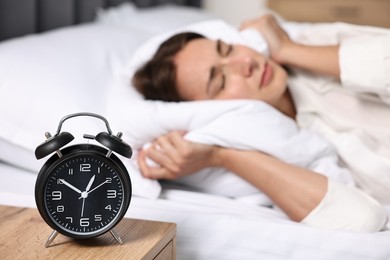 Photo of Woman sleeping in bed at lunch time, focus on alarm clock