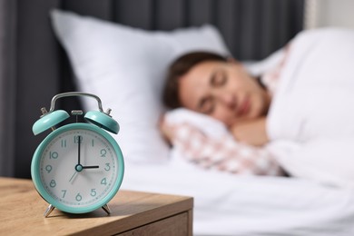 Photo of Woman sleeping in bed at lunch time, focus on alarm clock